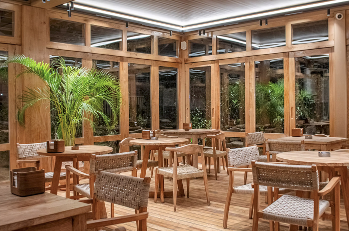 Michetta Bakery İstanbul cam cepheli salonunda ahşap masalar ve örgü sandalyeler