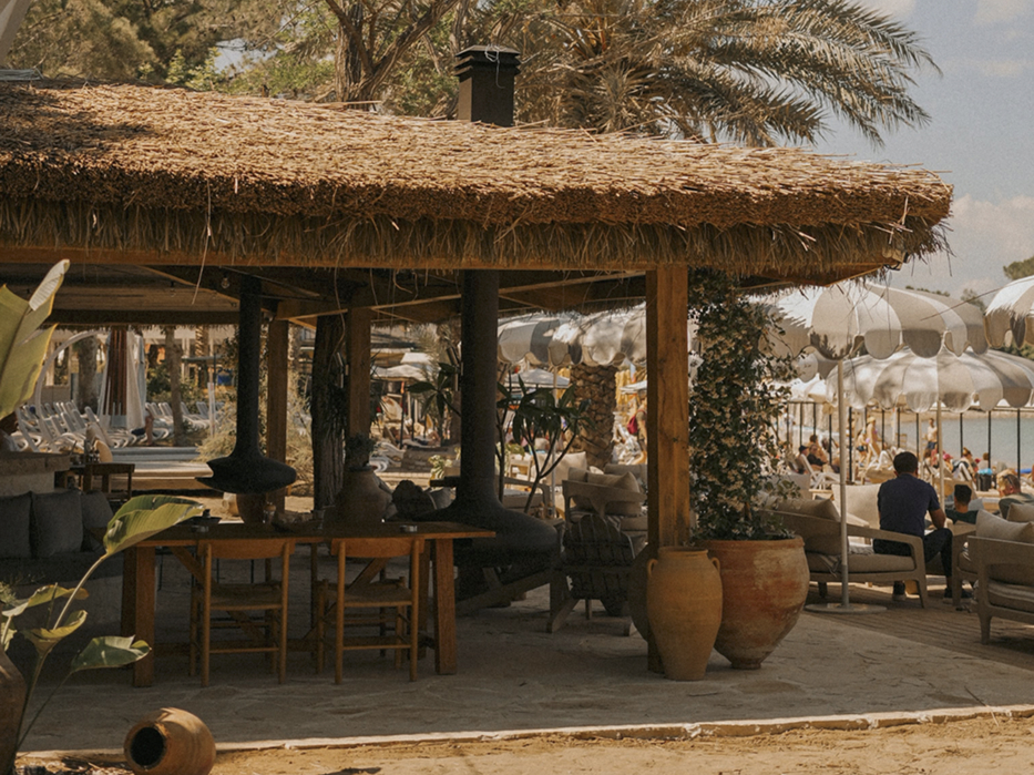 Qualista Beach Antalya hasır çatılı restoran alanında ahşap masa ve sandalyeler
