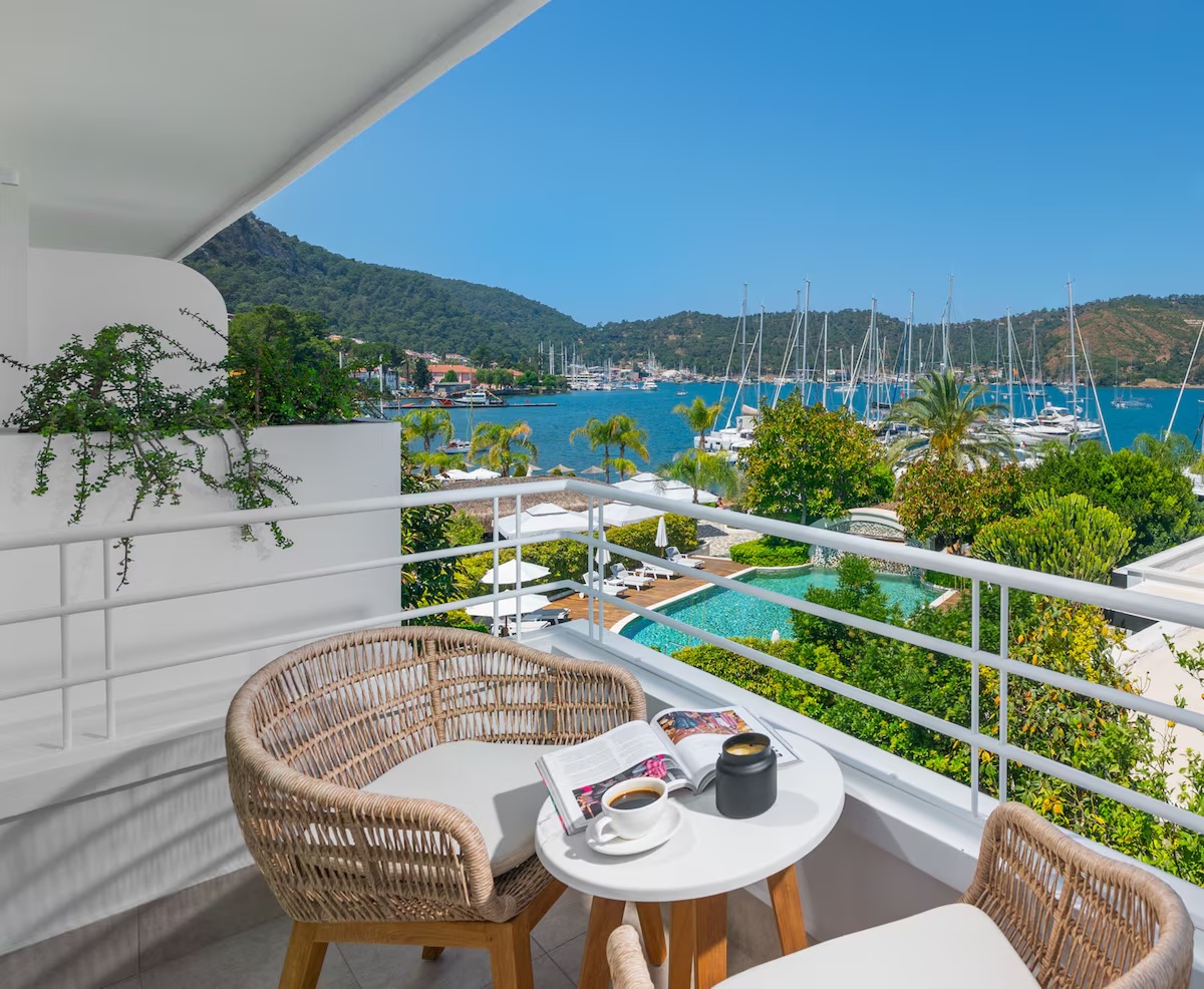 Yacht Classic Hotel Fethiye balkonunda marina manzarası ve örgü sandalyeler